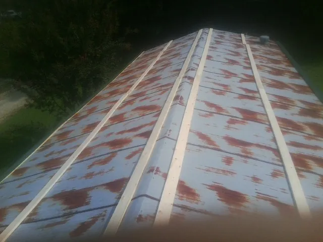 Rusted metal roof panels with new wood purlins before replacement — Storm Damage Roof Repair in South Windsor by Roofing Brothers